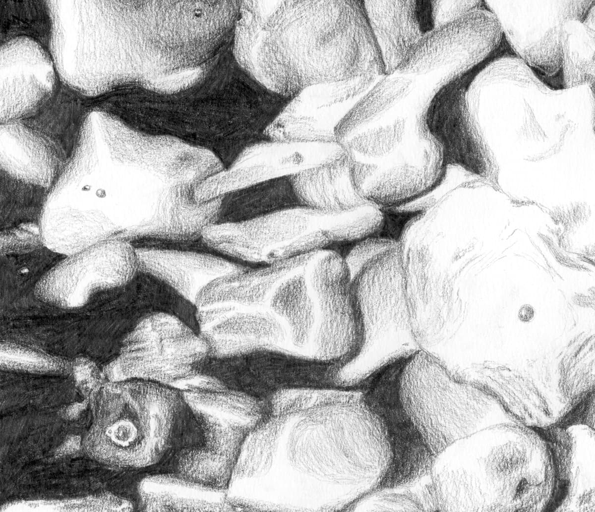 This pencil sketch depicts a close-up view of irregularly shaped stones piled together. The artist has used shading and texture to emphasize the depth and dimensionality of the stones, with light areas highlighting the smooth, rounded surfaces, and darker areas suggesting shadows between them. The stones vary in size and shape, some appearing more angular while others are smoother and more organic. The interplay of light and shadow gives the drawing a realistic and tactile quality, evoking the natural beauty of a stone arrangement.