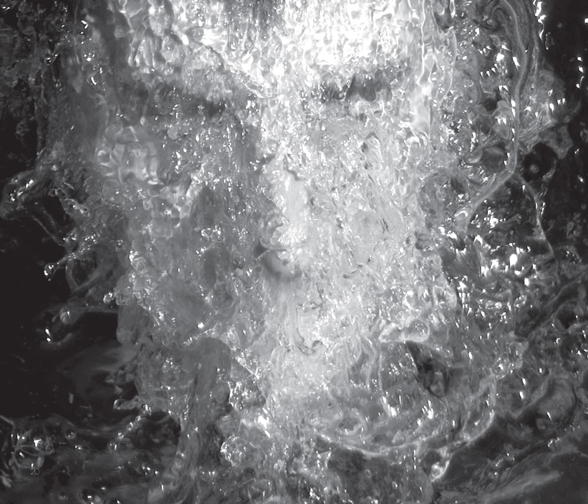 This black-and-white image features a human face submerged or enveloped in swirling, turbulent water. The water flows chaotically, partially obscuring the facial features, creating a dreamlike or surreal effect. The light reflecting off the water adds to the intensity of the image, with sharp highlights and deep shadows emphasizing the motion of the liquid. The face appears calm or expressionless, contrasting with the violent movement of the water around it. The image evokes a sense of being overwhelmed, as though the person is immersed in or consumed by the water, symbolizing emotional turmoil or transformation.