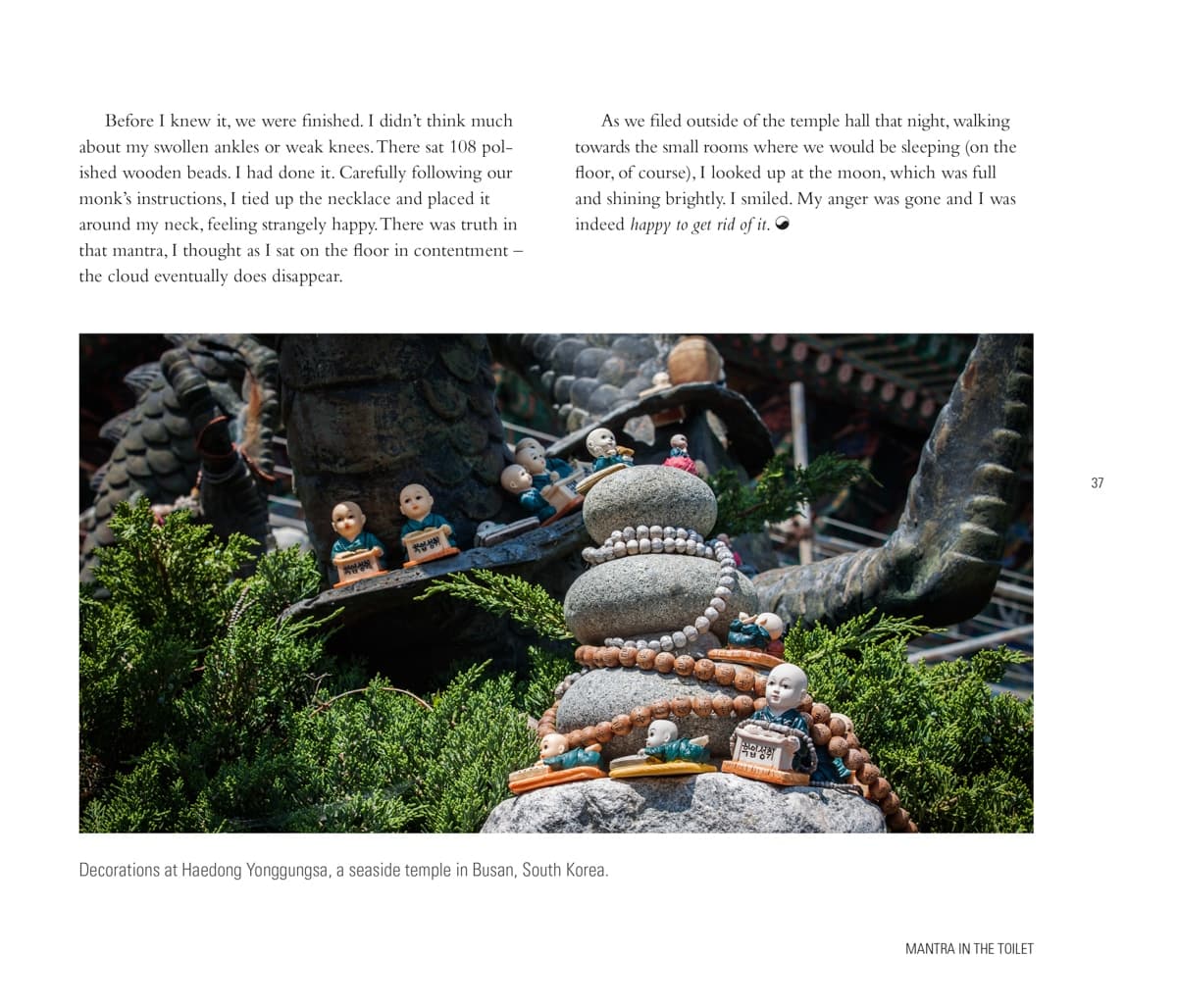 Small Buddha statues decorated with wooden beads and set on a stone sculpture at Haedong Yonggungsa, a seaside temple in Busan, South Korea.