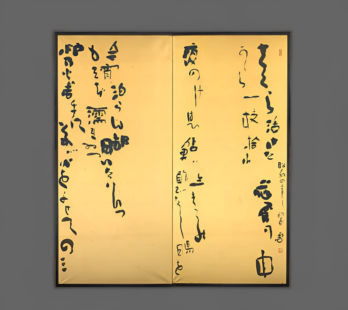 Two-panel folding screen featuring bold, freeform Japanese calligraphy in black ink on a shimmering gold background. The brushstrokes are expressive and varied in size, evoking a spontaneous, poetic rhythm. A red seal stamp marks the artist’s signature.
