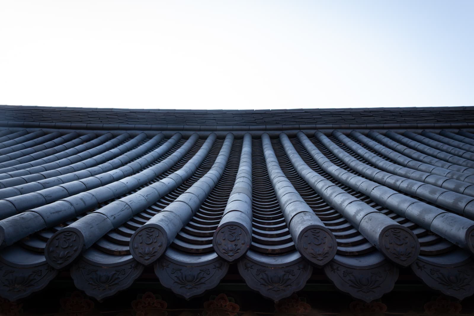 A close-up view of a traditional Korean roof with its distinct curved tiles arranged in neat rows.