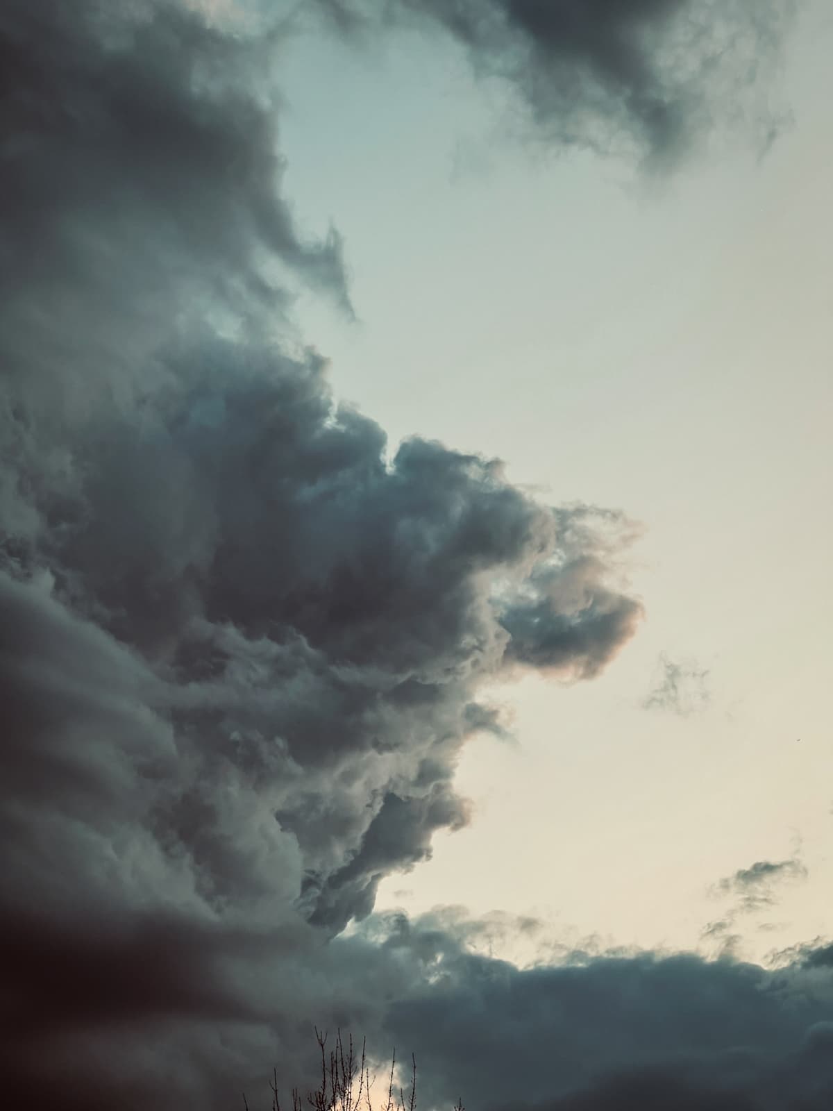 Dark, stormy clouds looming in the sky, with a small patch of light breaking through in the distance, creating a moody and atmospheric contrast.