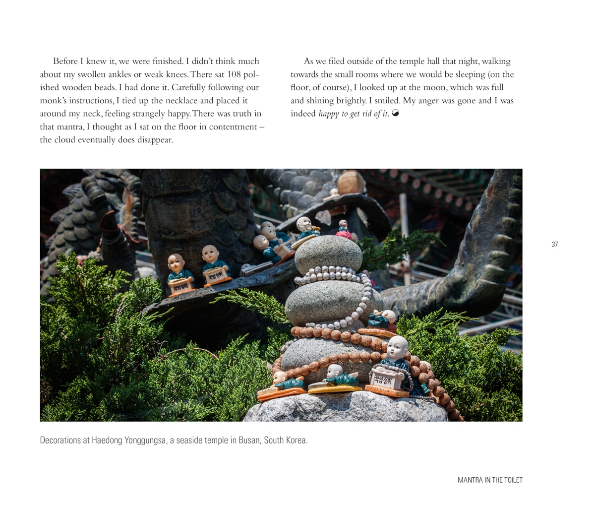 Small Buddha statues decorated with wooden beads and set on a stone sculpture at Haedong Yonggungsa, a seaside temple in Busan, South Korea.